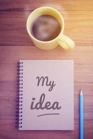 60837622 - cover page of notebook with word, my idea, and pencil and hot coffee on wood table, concept of start working on my plan in morning time, glow light effect, retro filter, vintage style.